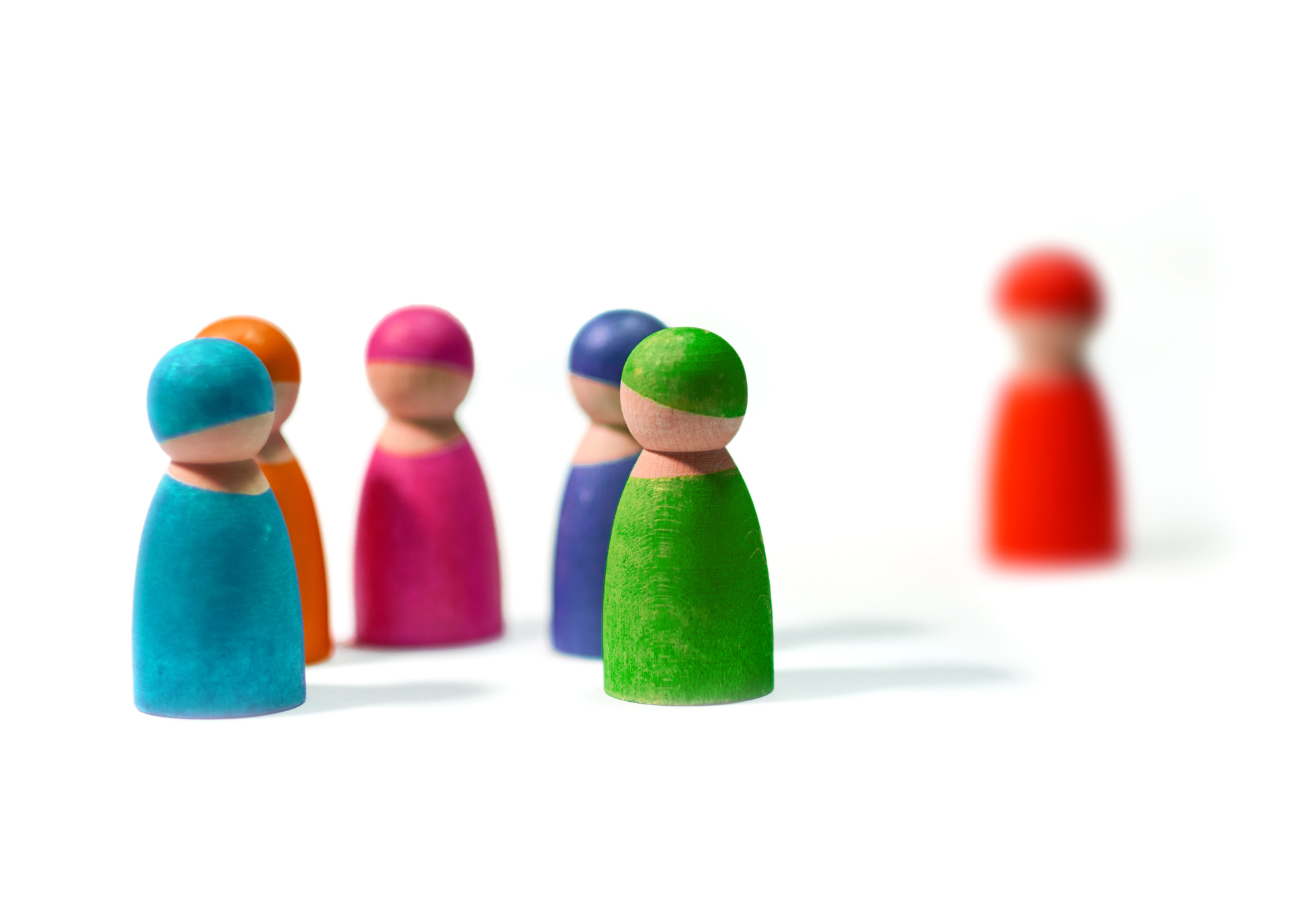 Spielfiguren im Kreis, eine mit Abstand zu den anderen.