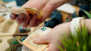Eine Person zählt Geldscheine in der Hand.