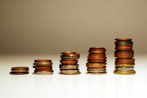 Geldmünzen in 5 Säulen, die von links nach rechts höher werden